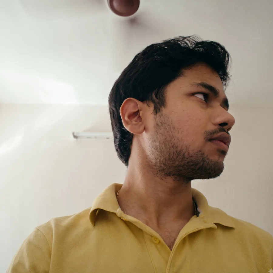 Young Lavi in a yellow polo, looking off to the side