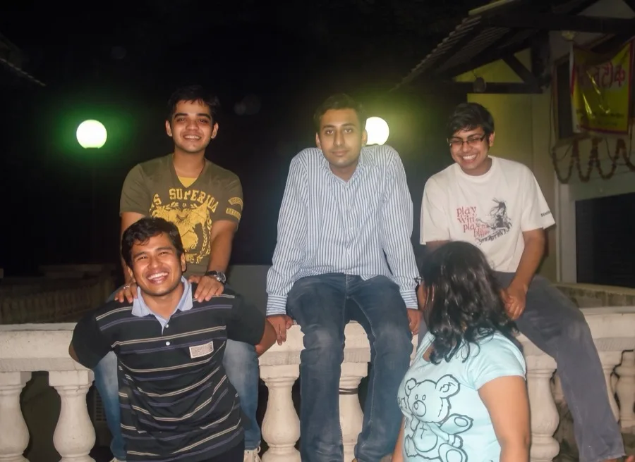 Lavi sits with friends on a white balustrade at night during his IIM Mumbai days.